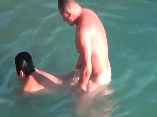Mature couple boldly fucks in the ocean